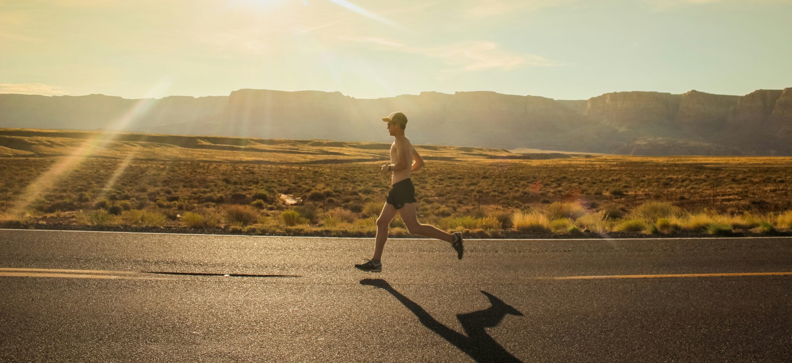 Runner training on an open road at sunrise