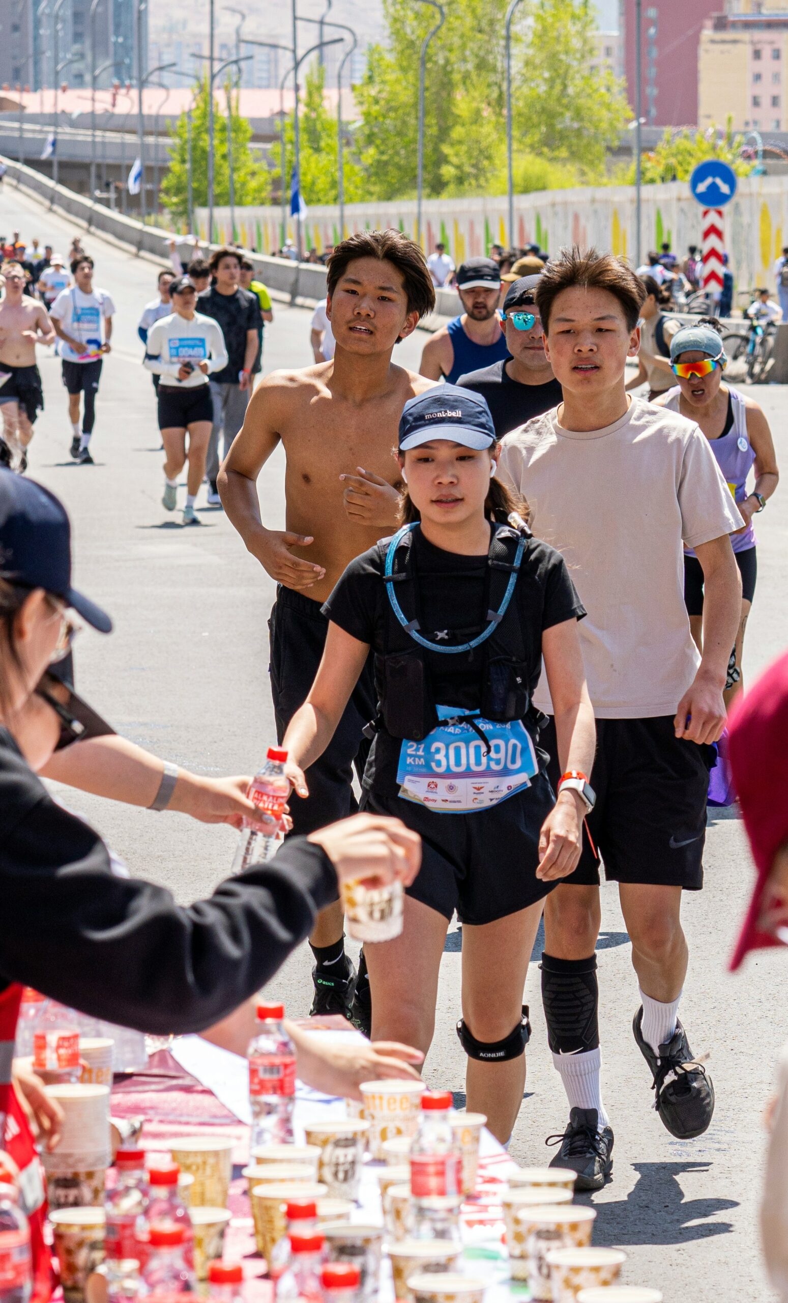 Runner drinking water at aid station during half marathon