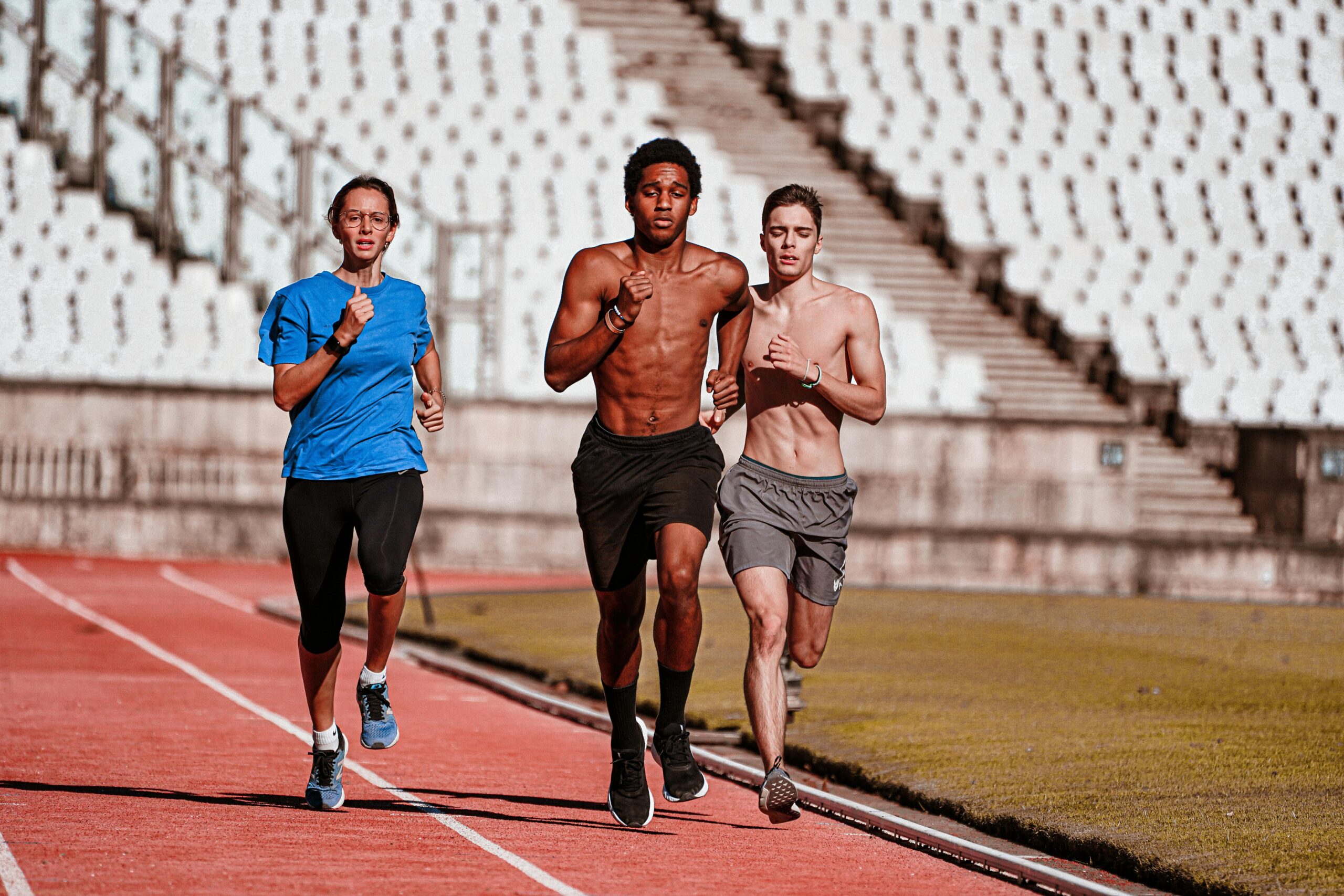Runners performing speed training on outdoor track for 10K preparation